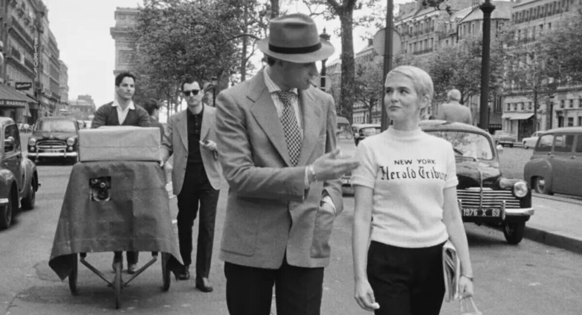 Actors from the movie Nouvelle Vague walk down Parisian street in black and white